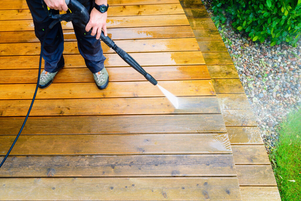 cleaning deck with a power washer - high water pressure cleaner on wooden deck surface